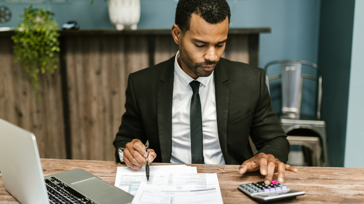 Advogado autônomo em seu escritório calculando tributos a serem pagos